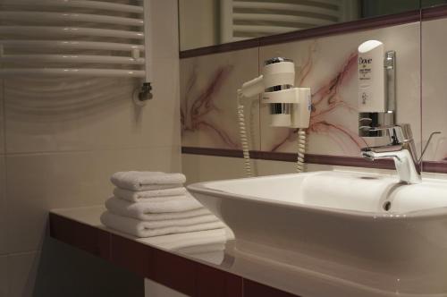 W łazience znajduje się umywalka, lustro i ręczniki. w obiekcie Apartament W&J w Szklarskiej Porębie