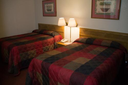 a hotel room with two beds and a phone at Tazewell Motor Lodge in Tazewell