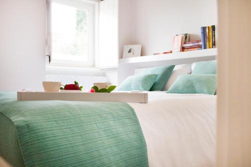una camera da letto con un letto con cuscini verdi e una finestra di Casa do Avô Serra a Leiria