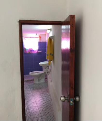 a bathroom with a toilet and a door with a mirror at Casa Colonial Centro in Mérida