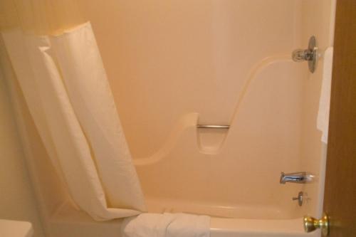 uma casa de banho com um chuveiro, uma banheira e um WC. em Tazewell Motor Lodge em Tazewell