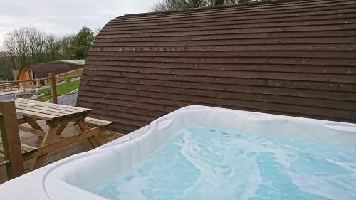 a hot tub sitting on a deck next to a building at Pods at Broadway in Laugharne