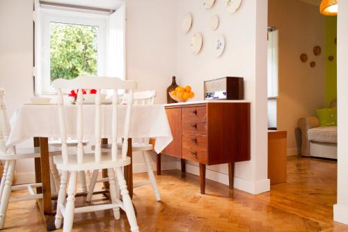 a dining room with a table and white chairs at Casa do Avô Serra in Leiria
