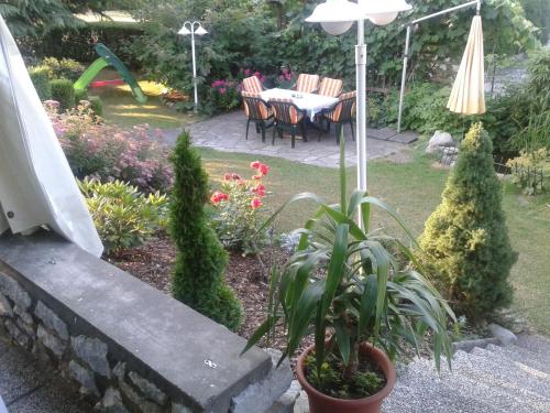 a garden with a table and chairs and an umbrella at Gästehaus Bärwald in Seeboden