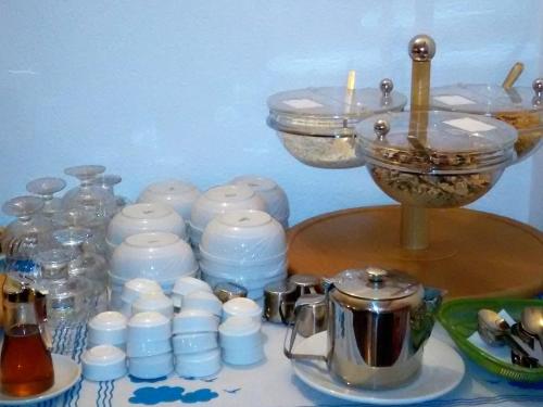 a table with dishes and a candle and a tea pot at Adonis Hotel Naxos in Apollon