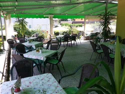 an empty patio with tables and chairs and tablesearcher at Gästehaus Bärwald in Seeboden