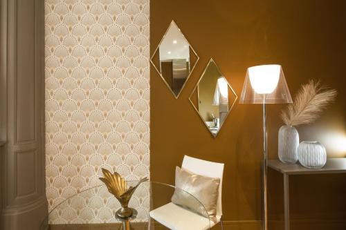 a room with a lamp and a chair and a mirror at MiHotel Gailleton in Lyon