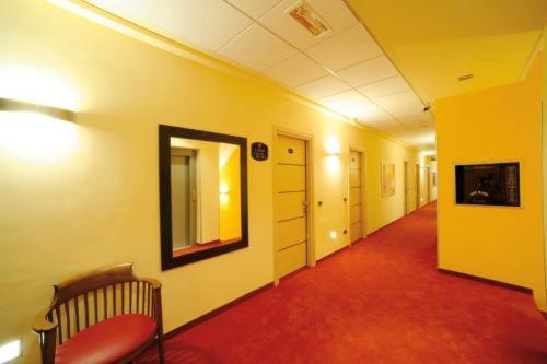 a hallway with a mirror and a chair in a room at Hotel Cristina in Rocca San Giovanni