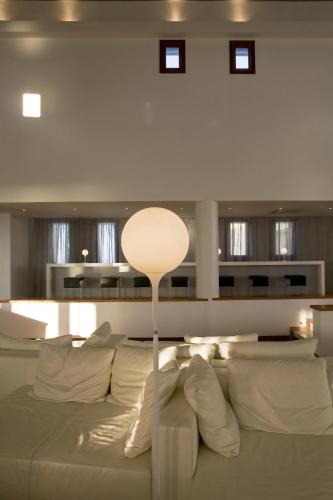 a living room with a white couch with pillows at The Majestic Hotel in Fira