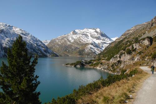 a person walking along a path next to a mountain lake at Gästehaus Bärwald in Seeboden