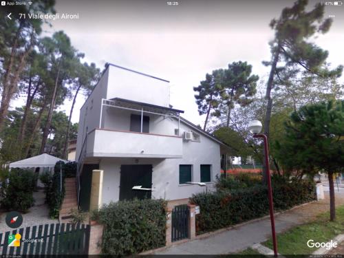 a white house with a black door at Appartamento La Valle in Marina Romea