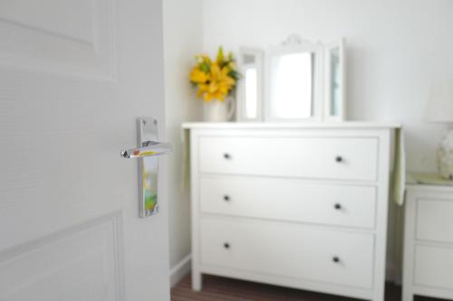 a white dresser with a mirror and a white dresser at Krissie's in Marazion