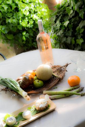 - une table avec des légumes et une bouteille dans l'établissement Maison d'hôtes , ancien Hôtel des colonnes, à Riez