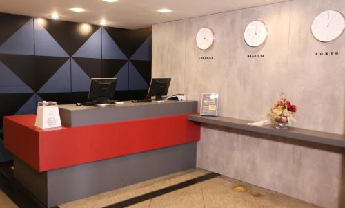 a lobby with a counter with clocks on the wall at Bristol Metropolitan Curitiba Centro in Curitiba
