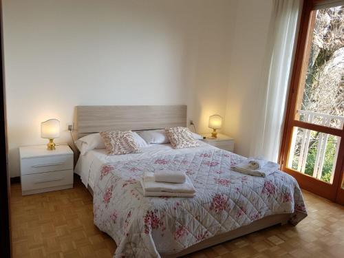 ヴァレーゼにあるAppartamento Villa Adrianaのベッドルーム1室(ベッド1台、テーブル2台、ランプ2つ付)