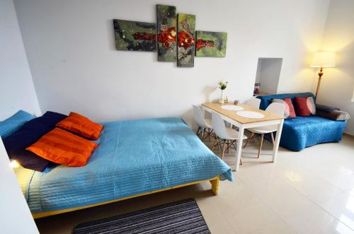 Cette chambre comprend un lit, une table et un canapé. dans l'établissement Studio Aleja 77, à Częstochowa