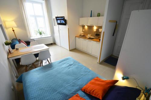sypialnia z łóżkiem i stołem oraz kuchnia w obiekcie Studio Aleja 77 w mieście Częstochowa