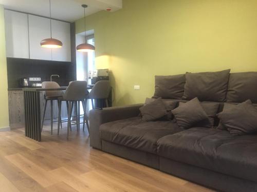 a living room with a brown couch and a kitchen at Hygge in Tatariv