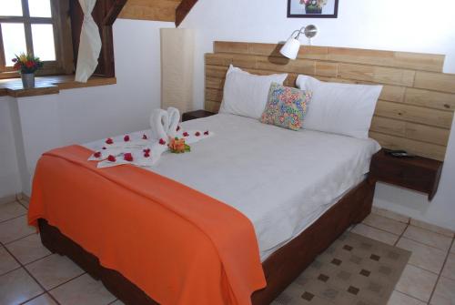 a bedroom with a large bed with flowers on it at Hotel Rancho Constanza & Cabañas de la Montaña in Constanza