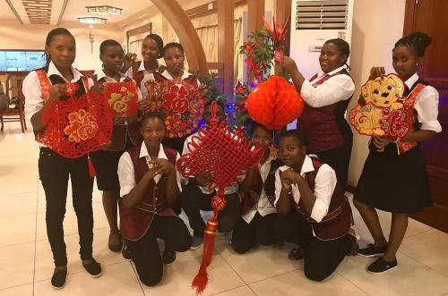 a group of children in school uniforms posing for a picture at Great Wall Hotel in Dar es Salaam