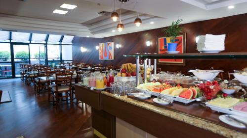 a buffet line with food and drinks in a restaurant at Bristol Metropolitan Curitiba Centro in Curitiba