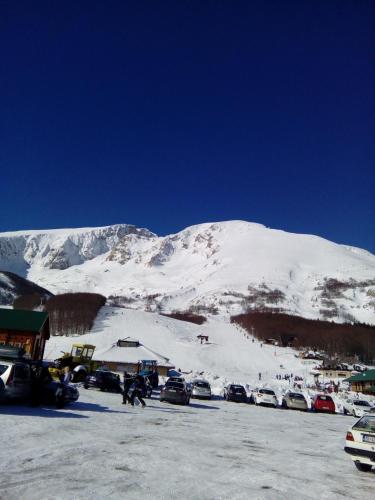 a parking lot with a snow covered mountain in the background at Rooms Apartment Durmitor in Žabljak