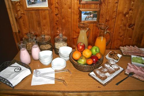 a wooden table with a bowl of fruit and other foods at Lodge El Mirador De Guadal in Puerto Guadal