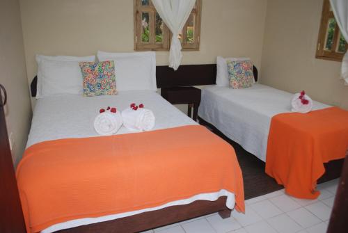 a bedroom with two beds with towels on them at Hotel Rancho Constanza & Cabañas de la Montaña in Constanza