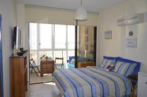 a bedroom with a bed and a sliding glass door at Montehugh in Larnaka