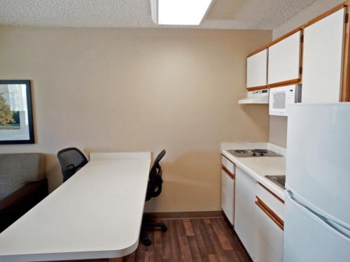 a kitchen with a white table and a refrigerator at Extended Stay America Suites - Secaucus - New York City Area in Secaucus