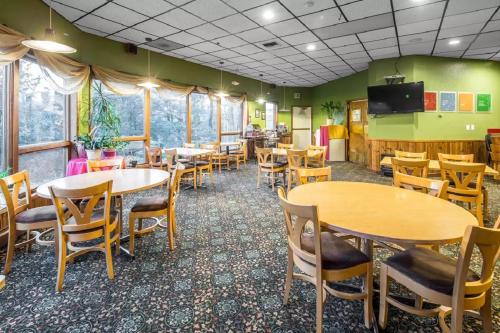 a dining room with tables and chairs and a tv at Quality Inn Kodiak in Kodiak