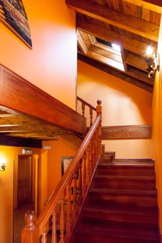 a winding staircase in a house with wooden ceilings at Pensión la Campanilla in La Penilla