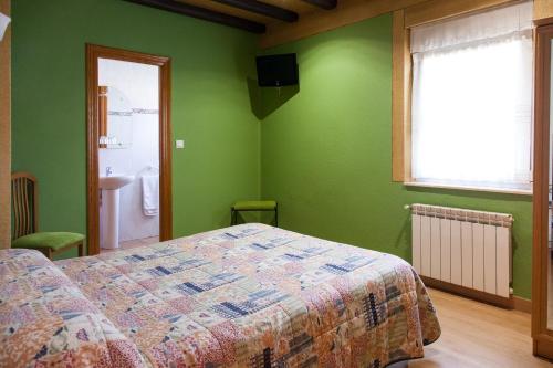 a bedroom with green walls and a bed and a window at Pensión la Campanilla in La Penilla