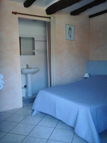 une chambre avec un lit et un lavabo dans l'établissement La Tour, à Creysse