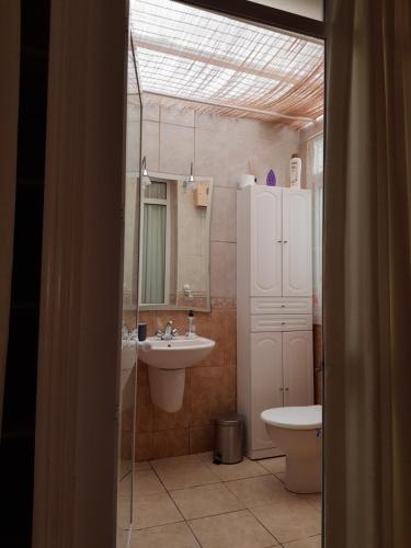a bathroom with a sink and a toilet and a mirror at Roberto Guest House in Benalmádena