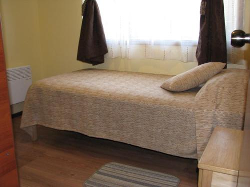a small bed in a room with a window at Portal Austral in Puerto Montt