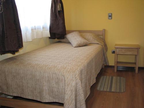 a bedroom with a bed with a window and a table at Portal Austral in Puerto Montt