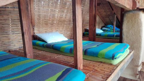 a room with two beds in a wicker shelter at Chalet Casa de Teja in Tinjacá