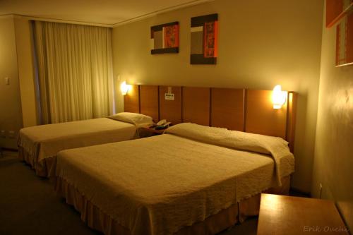 a hotel room with two beds in a room at Barbur Plaza Hotel in Ponta Grossa