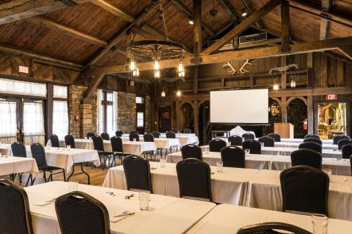 a conference room with tables and chairs and a projection screen at Abe Martin Lodge & Cabins in Nashville