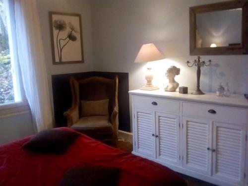 a bedroom with a bed and a chair and a dresser at La corniche in Chaumont