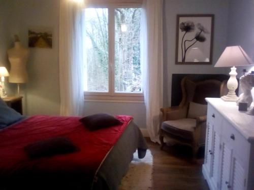 a bedroom with a bed and a window and a chair at La corniche in Chaumont