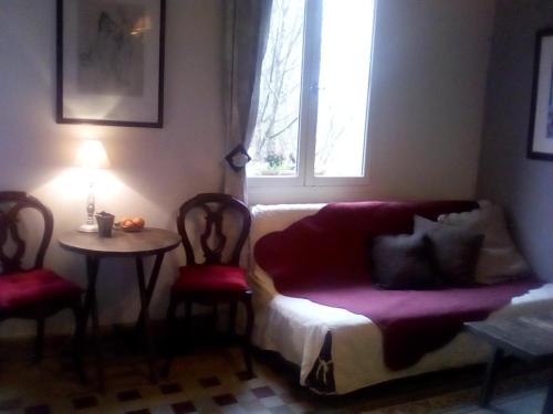 a living room with a couch and a table and a window at La corniche in Chaumont