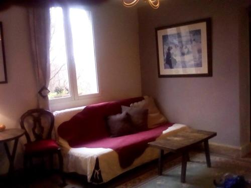 uma sala de estar com um sofá e uma janela em La corniche em Chaumont