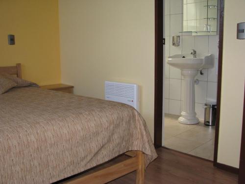 a bedroom with a bed and a sink at Portal Austral in Puerto Montt
