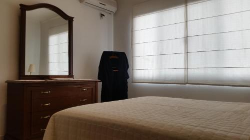 Schlafzimmer mit einem Bett, einer Kommode und einem Spiegel in der Unterkunft Casa de Leny cerca de la Feria Exposición in Santa Cruz de la Sierra