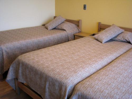 two beds in a hotel room with at Portal Austral in Puerto Montt