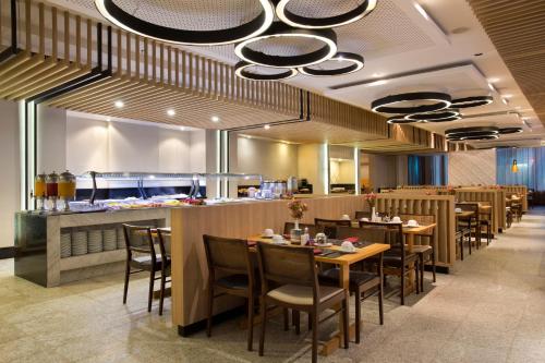Un restaurante con mesas y sillas y un bar. en Royal Rio Palace Hotel, en Río de Janeiro