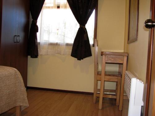 a room with a window with a chair and a table at Portal Austral in Puerto Montt