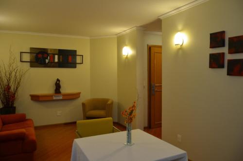 a living room with a table with a vase on it at Barbur Plaza Hotel in Ponta Grossa